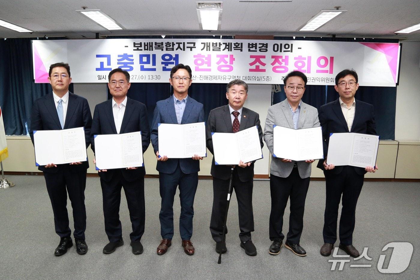 김정기 보배산업 대표&#40;왼쪽부터&#41;, 조선민 창원시 해양항만수산국장, 한준도 두동발전위원회 회장, 유철환 국민권익위원회 위원장, 박성호 부산진해경제자유구역청장, 이현조 산업통상자원부 경제자유구역 기획단장이 27일 조정회의에서 조정서를 들고 있다.&#40;경자청 제공. 재판매 및 DB 금지&#41;