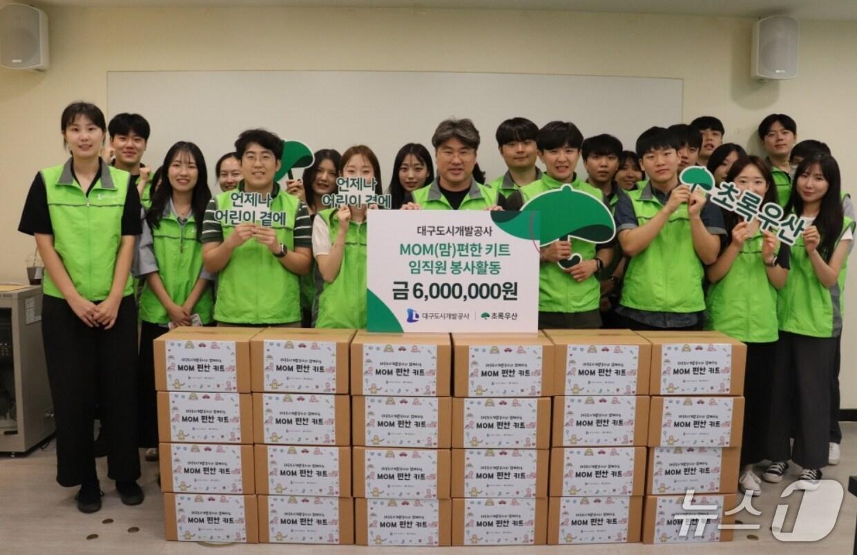 본문 이미지 - 저소득 가정에 전달될 'MOM(맘) 편한 키트' 포장에 참여한 대구도시개발공사 임직원과 인턴직원들이 파이팅을 외치고 있다.(대구도시개발공사 제공. 재판매 및 DB 금지)