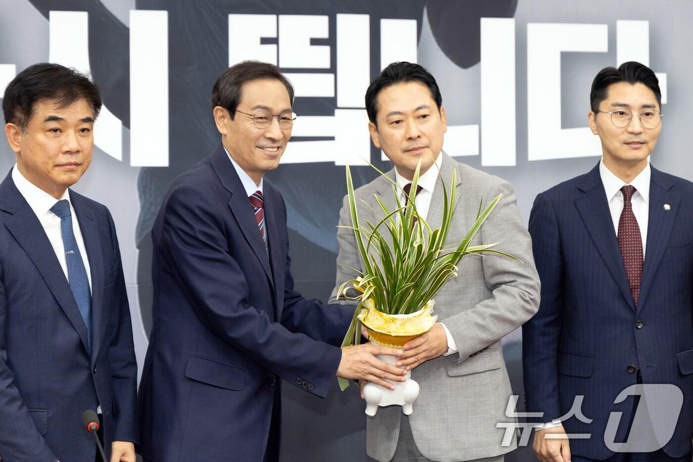 장동혁 국민의힘 신임 당대표가 27일 오후 서울 여의도 국회에서 우상호 대통령실 정무수석으로부터 축하난을 받고 있다. 2025.8.27/뉴스1 ⓒ News1 이승배 기자