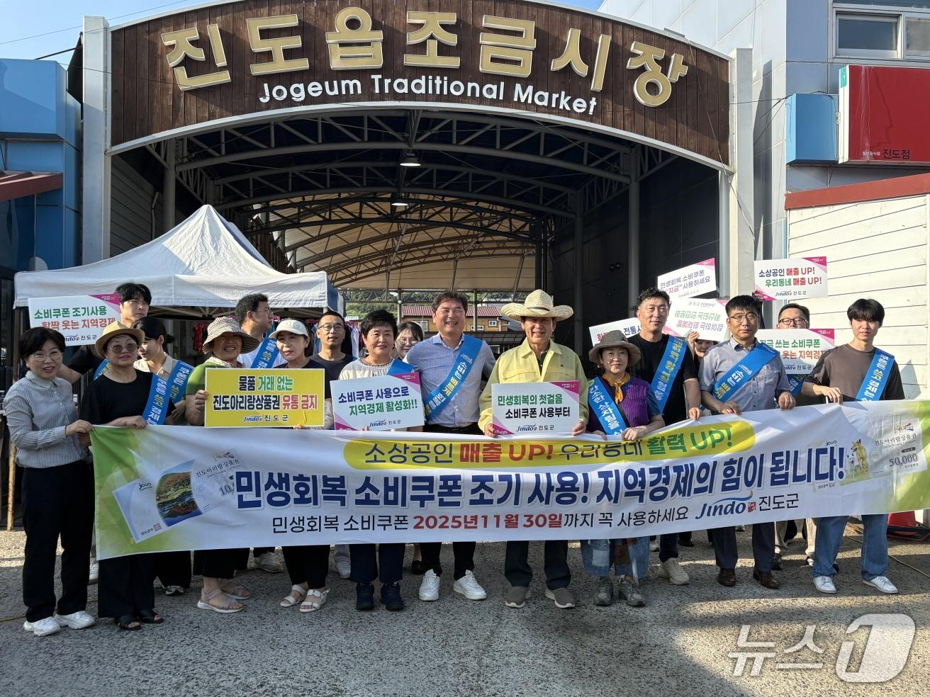 본문 이미지 - 김희수 진도군수 등 진도군 관계자들이 진도읍 조금시장에서  민생회복 소비쿠폰 조기 사용 촉진 캠페인을 실시하고 있다. (진도군 제공, 재판매 및 DB 금지)/뉴스1