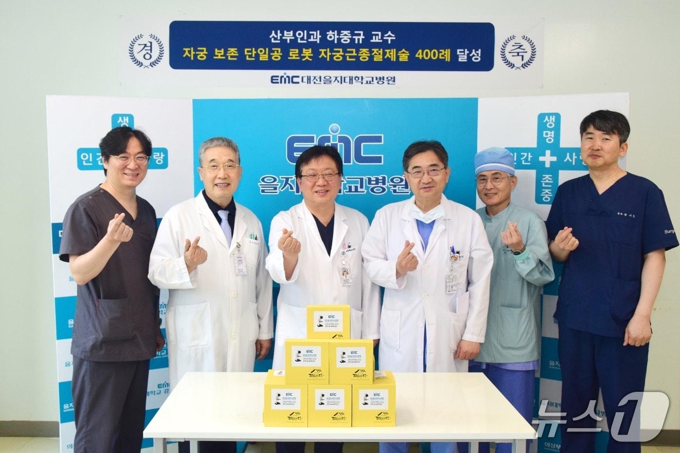 본문 이미지 - 대전을지대학교병원 산부인과 하중규 교수(왼쪽 세 번째가 ‘자궁 보존 단일공 로봇 자궁근종절제술’ 400례를 달성했다. 김하용 대전을지대학교병원장(사진 네 번째)와 기념 촬영하는 모습. (대전을지대학교병원 제공. 재판매 및 DB금지)2025.8.28/뉴스1