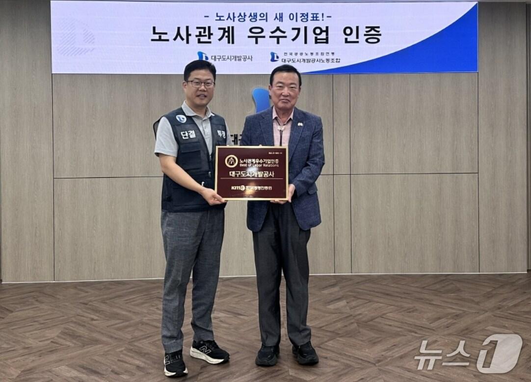 본문 이미지 - 정명섭 대구도시개발공사 사장(오른쪽)과 천상필 노동조합위원장이 노사관계우수기업 인증패를 들어 보이고 있다.(대구도시개발공사 제공. 재판매 및 DB 금지)