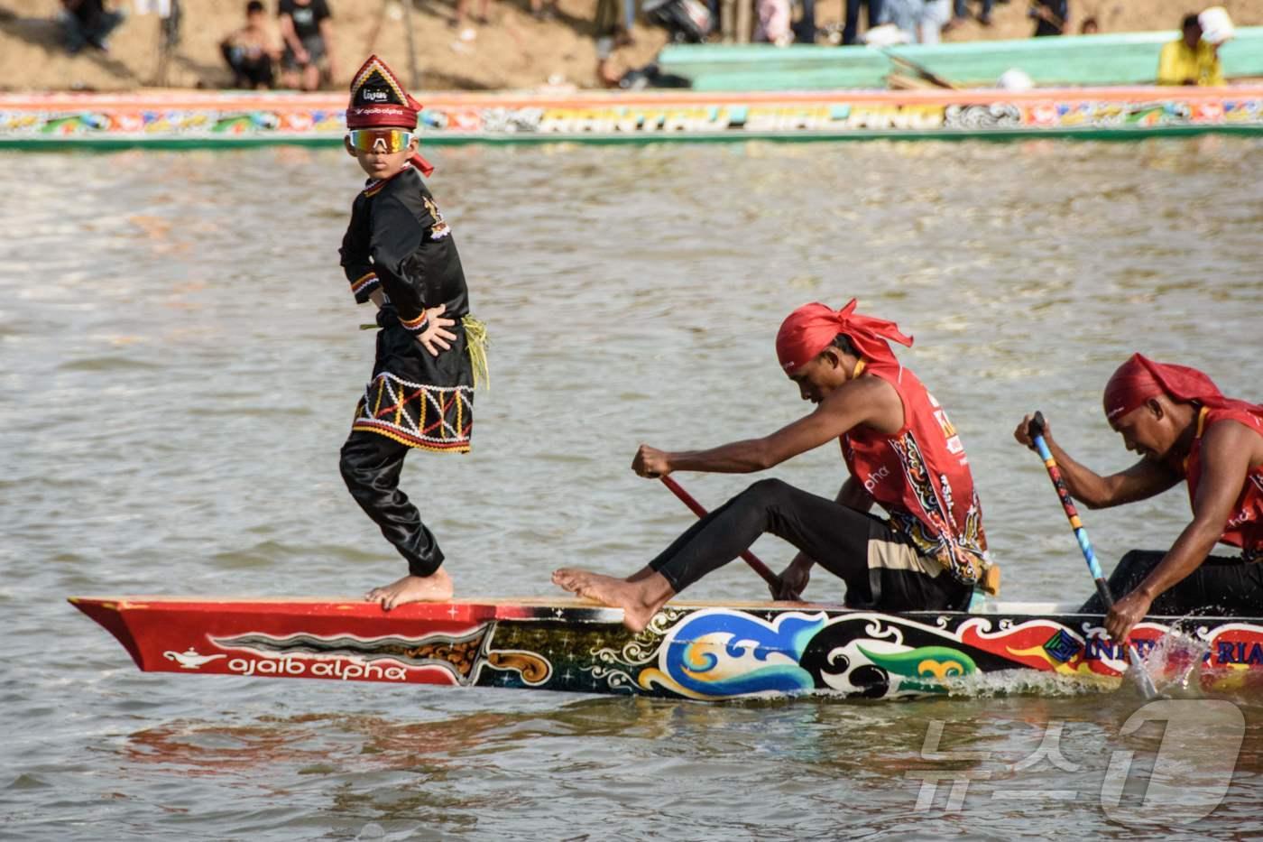인도네시아 리아우주 쿠안탄강에서 열린 파추 잘루르&#40;Pacu Jalur&#41; 전통 보트 경주 축제중 뱃머리에서 춤을 추며 SNS에서 화제를 모은 11세 소년 레이얀 아르칸 디카&#40;왼쪽&#41;가 공연을 선보이고 있다. 2025.8.21 ⓒ AFP=뉴스1