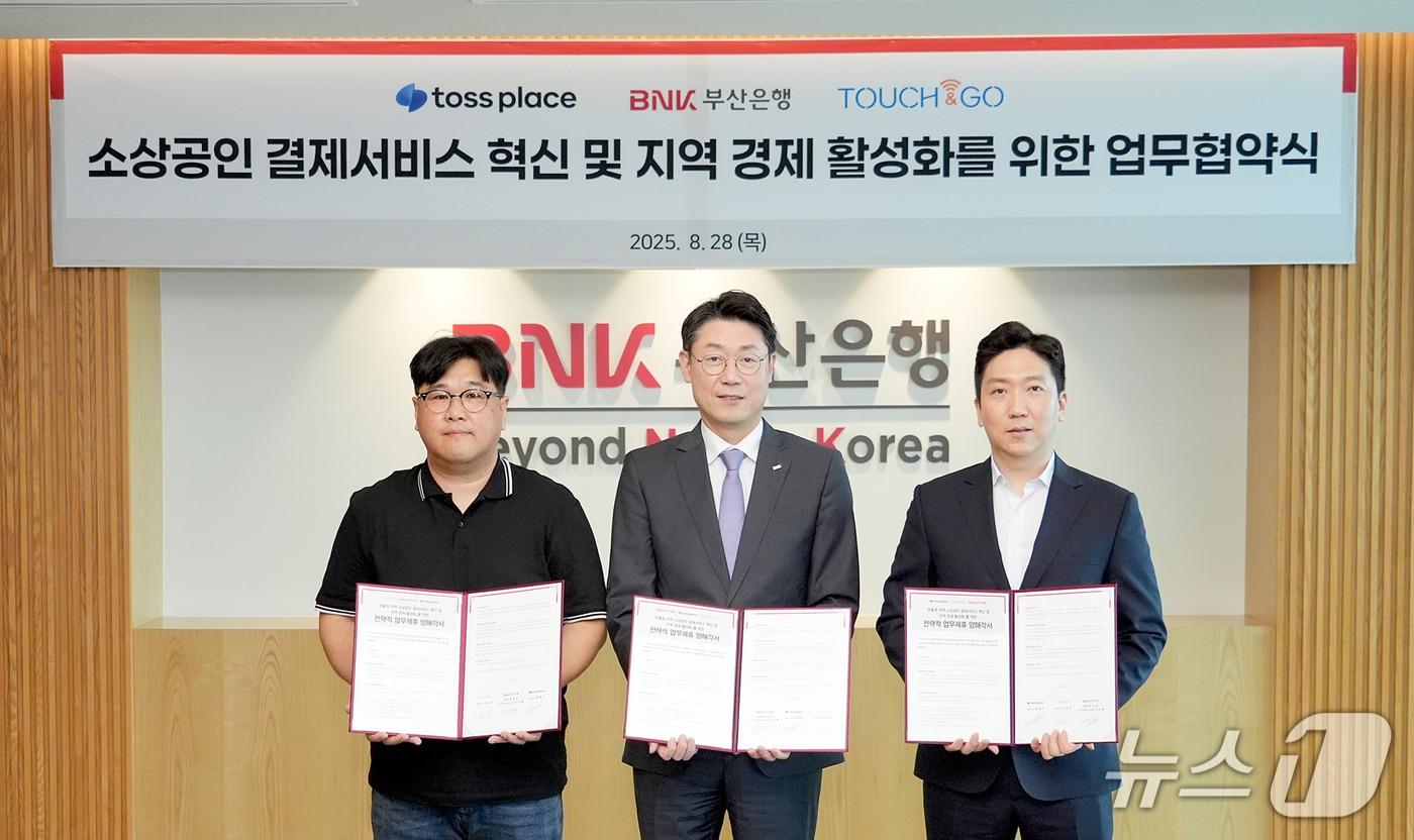 28일 부산 남구 문현동 BNK부산은행 본점에서 소상공인 결제서비스 혁신과 지역경제 활성화를 위한 전략적 업무협약(MOU)식에서 차정호 터치앤고 대표(왼쪽부터), 이주형 BNK부산은행 디지털금융그룹장, 최재호 토스플레이스 대표가 협약서를 들어 보이고 있다. (BNK부산은행 제공. 재판매 및 DB 금지)