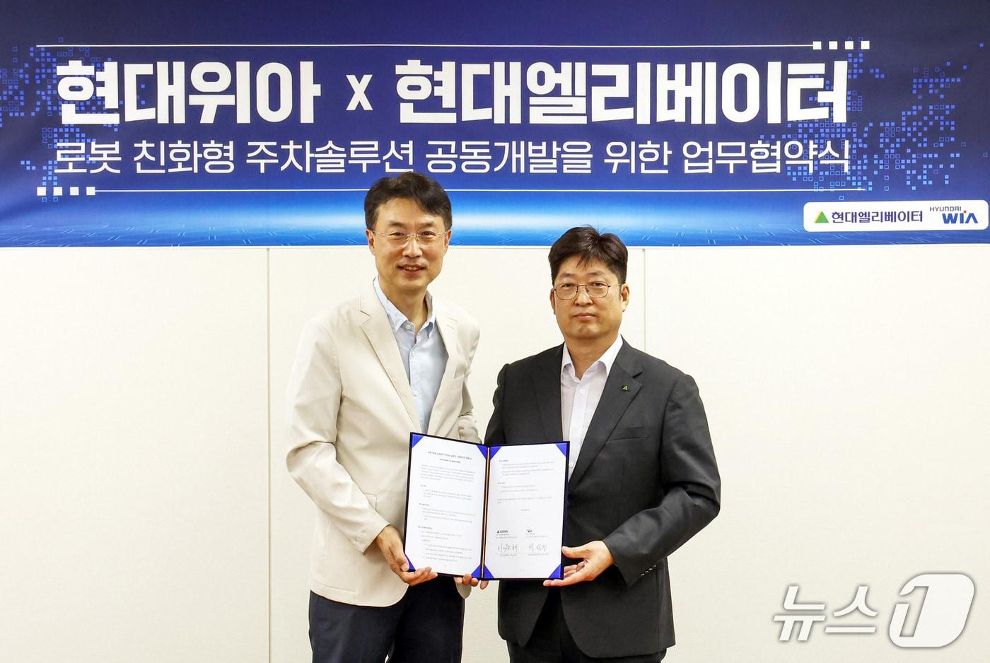 이원해 현대엘리베이터 승강기사업본부장&#40;오른쪽&#41;과 백익진 현대위아 모빌리티솔루션사업부장이 28일 오후 경기 현대위아 의왕연구소에서 업무협약&#40;MOU&#41;을 체결한 뒤 기념촬영을 하고 있다&#40;현대엘리베이터 제공&#41;