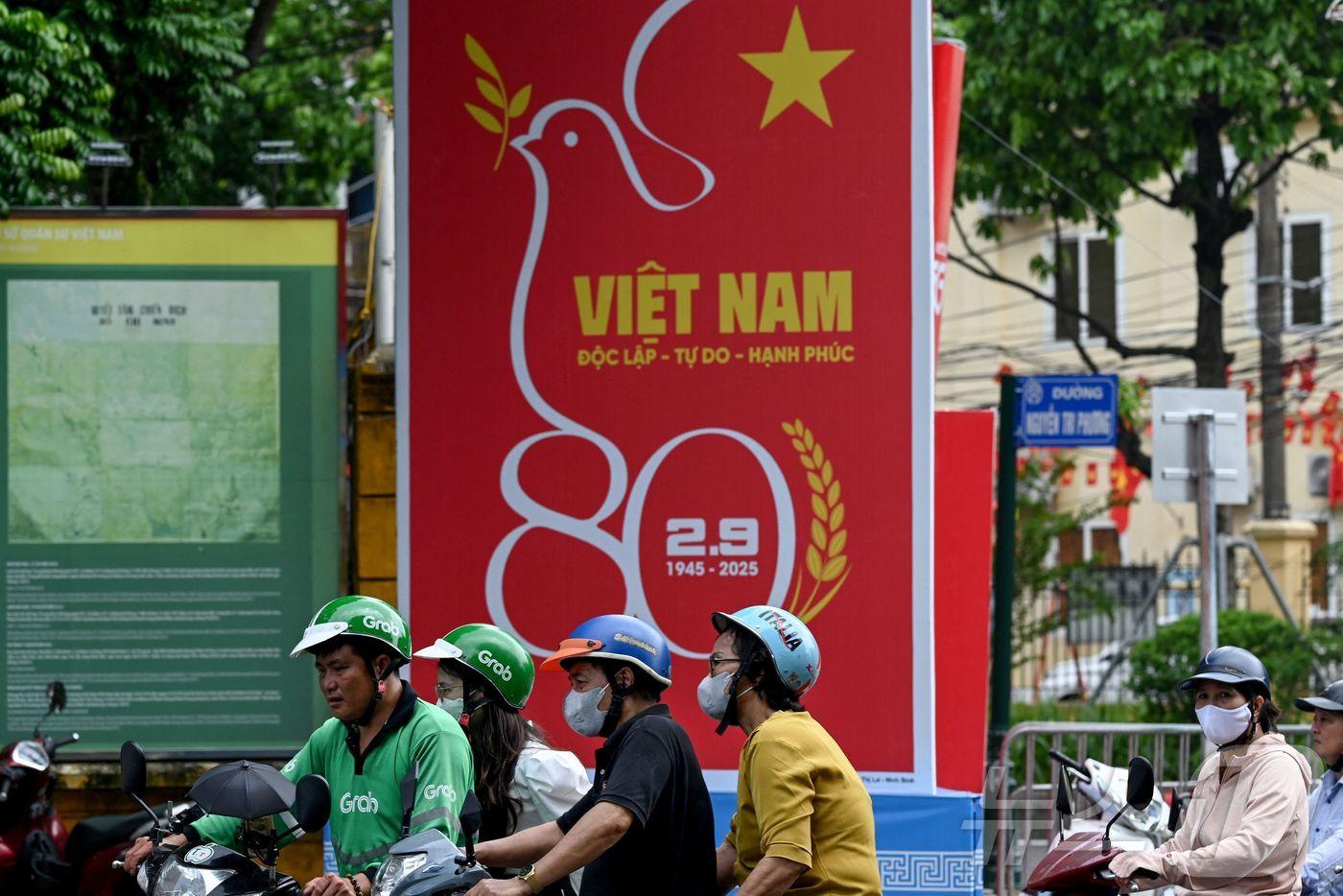 28일(현지시간) 베트남 하노이에서 오토바이를 탄 시민들이 제80주년 국경절을 기념하는 광고물 앞을 지나치고 있다. 2025.08.28. ⓒ AFP=뉴스1 ⓒ News1 윤다정 기자