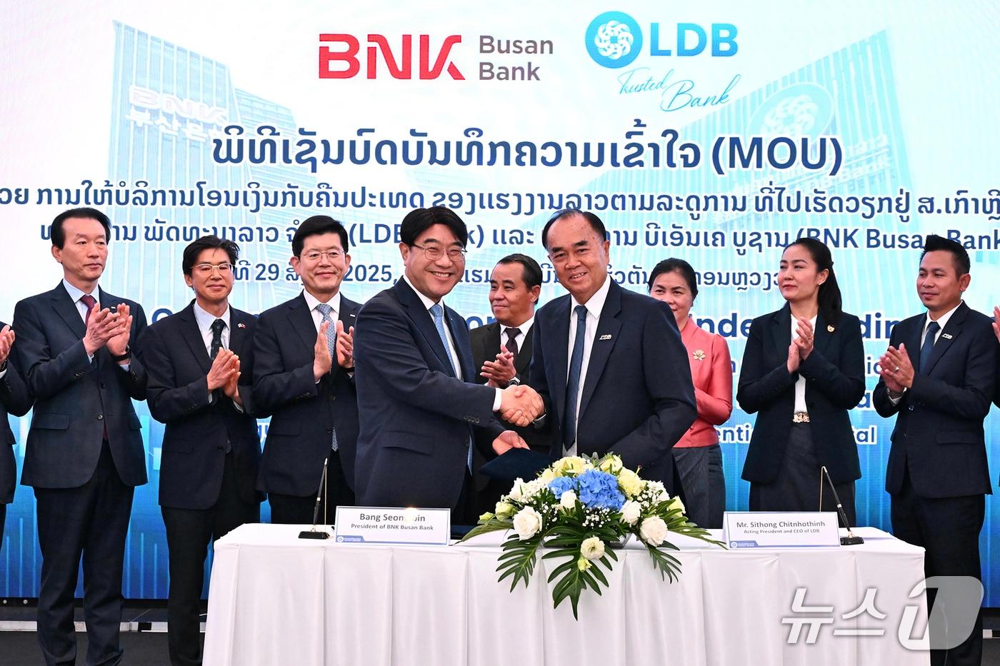 방성빈 BNK부산은행장(앞줄 왼쪽)이 29일 라오스 비엔티안에서 시치쏜 테파시 라오스개발은행 총괄 회장과 '라오스 계절근로자 집금 사업'에 관한 양해각서(MOU)를 체결하고 있다. (부산은행 제공. 재판매 및 DB 금지)