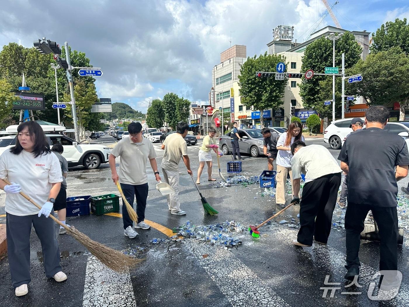 본문 이미지 - 도로에 쏟아진 맥주병을 청소하고 있는 대전시체육회 관계자들과 시민들(대전시체육회 제공) /뉴스1