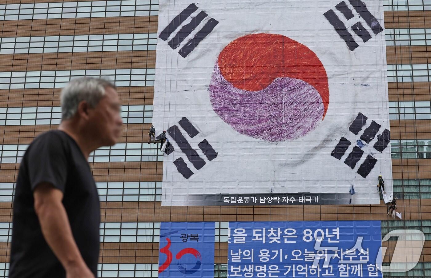 광복 80주년을 앞둔 지난 3일 서울 종로구 광화문 교보생명 빌딩 외벽에 독립운동가 남상락 자수태극기가 래핑되고 있다. /뉴스1 ⓒ News1 장수영 기자