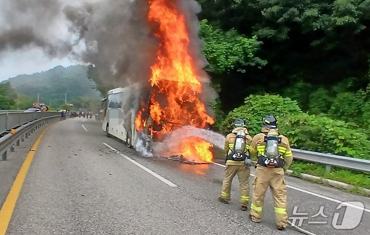 본문 이미지 - 3일 오후 3시 52분쯤 충북 괴산 동부리 34번 국도를 달리던 관광버스에서 불이 나 소방대원들이 진화작업을 하고 있다.(괴산소방서 제공, 재판매 및 DB금지)/뉴스1