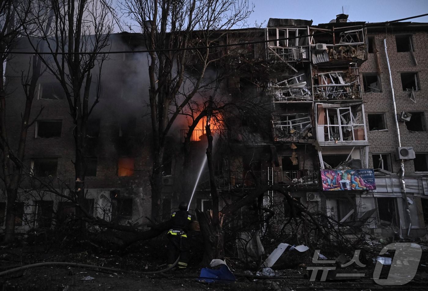 우크라이나 자포리자의 한 아파트 건물에서 한 소방관이 진화 작업을 벌이고 있다. ⓒ 로이터=뉴스1 ⓒ News1 윤다정 기자