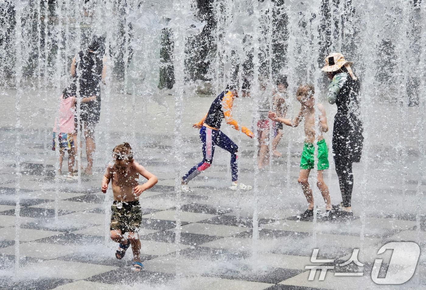 서울 성동구 서울숲에서 시민들이 바닥 분수에서 나오는 물줄기를 맞으며 더위를 식히고 있다./뉴스1 ⓒ News1 황덕현　기후환경전문기자