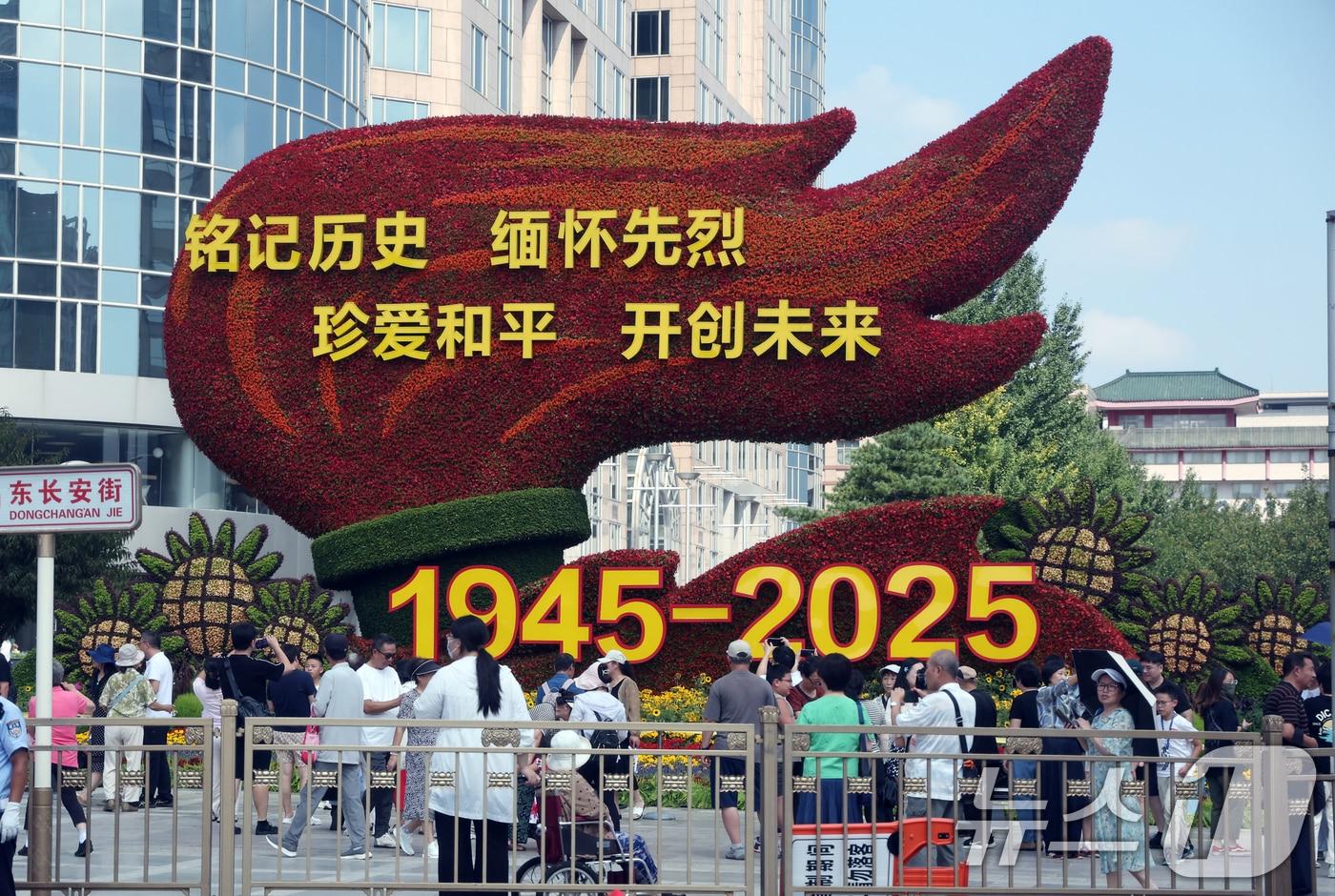 중국의 항일전쟁 및 세계 반파시스트 전쟁&#40;제2차 세계대전&#41; 승리 80주년&#40;전승절&#41; 기념 열병식을 사흘 앞둔 31일 중국 베이징 천안문 인근 거리에 설치된 꽃 조형물 앞에서 행인들이 기념 사진을 찍고 있다. 2025.8.31/뉴스1 ⓒ News1 박정호 기자