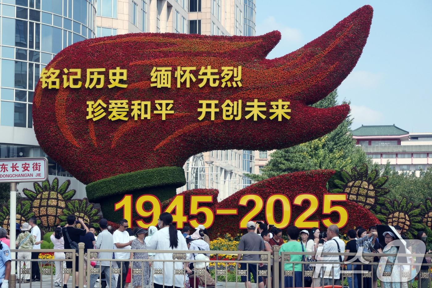 중국의 항일전쟁 및 세계 반파시스트 전쟁&#40;제2차 세계대전&#41; 승리 80주년&#40;전승절&#41; 기념 열병식을 사흘 앞둔 31일 중국 베이징 천안문 인근 거리에 설치된 꽃 조형물 앞에서 행인들이 기념 사진을 찍고 있다. 2025.8.31/뉴스1 ⓒ News1 박정호 기자