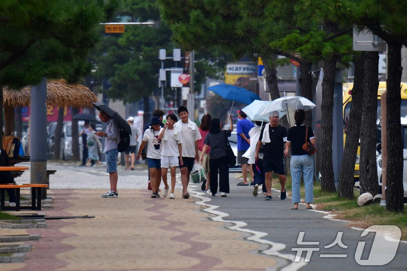 8월의 마지막 날인 31일 오후 경북 포항시 북구 영일대해수욕장을 찾은 관광객들이 이슬비를 피해 걸어가고 있다. 2025.8.31/뉴스1 ⓒ News1 최창호 기자