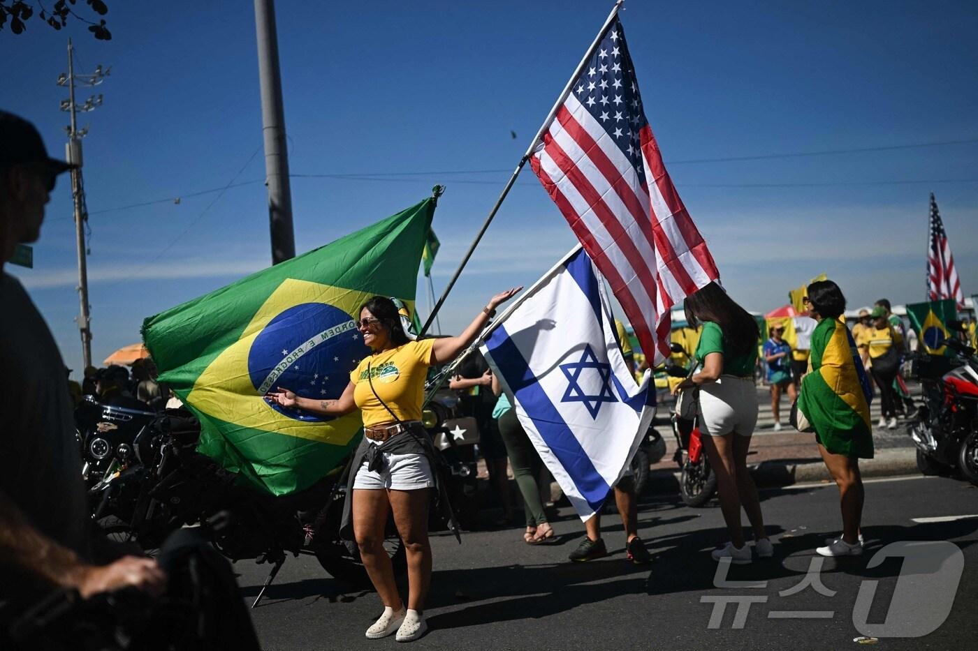 3일&#40;현지시간&#41; 쿠데타 혐의로 재판을 받고 있는 자이르 보우소나루 전 브라질 대통령의 지지자가 리우데자네이루에서 브라질과 이스라엘 국기, 미국 성조기를 들고 시위를 하고 있다. 2025.08.03 ⓒ AFP=뉴스1 ⓒ News1 김지완 기자