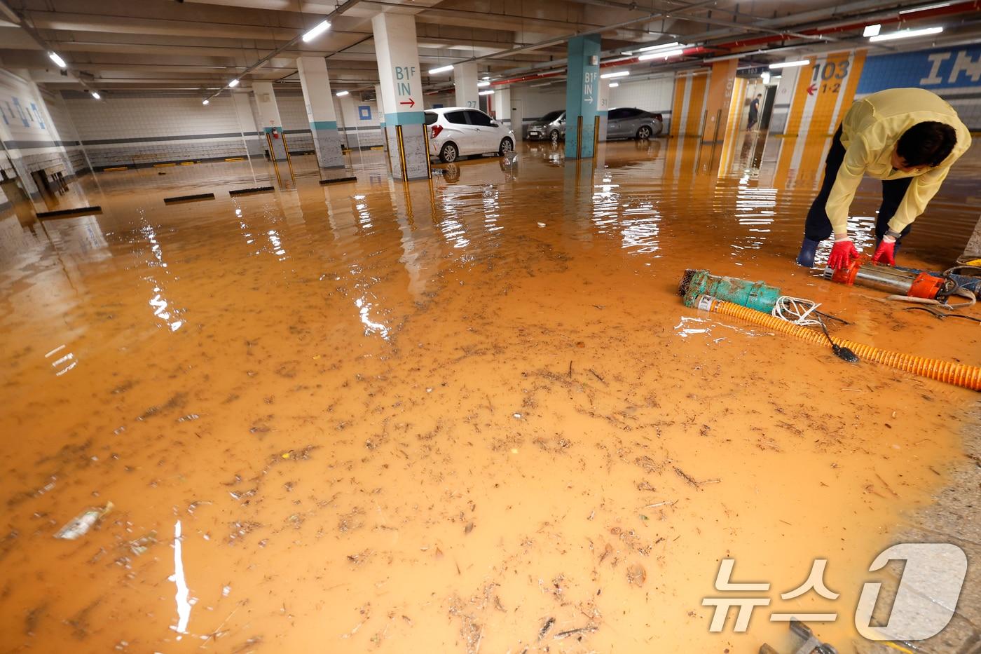 4일 전남 무안군 무안읍 한 아파트 주차장이 폭우에 침수돼 주민들이 흙탕물을 퍼내고 있다. 2025.8.4/뉴스1 ⓒ News1 김태성 기자