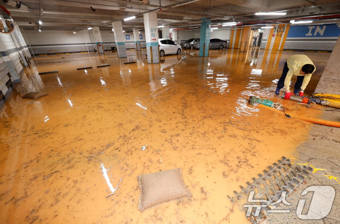 4일 전남 무안군 무안읍 한 아파트 주차장이 폭우에 침수돼 주민들이 흙탕물을 퍼내고 있다. 2025.8.4/뉴스1 ⓒ News1 김태성 기자