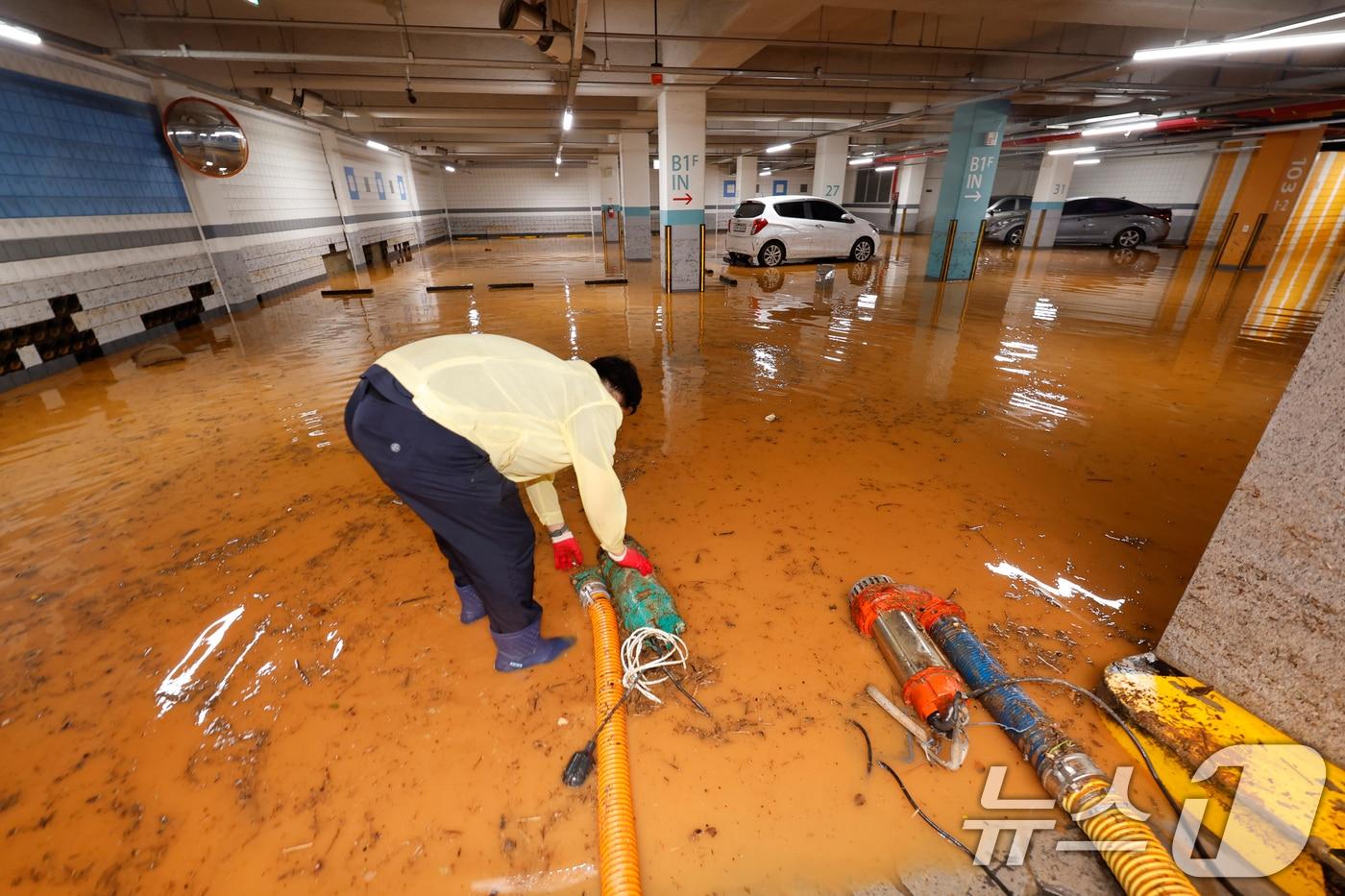 4일 전남 무안군 무안읍 한 아파트 주차장이 폭우에 침수돼 주민들이 흙탕물을 퍼내고 있다. 2025.8.4/뉴스1 ⓒ News1 김태성 기자