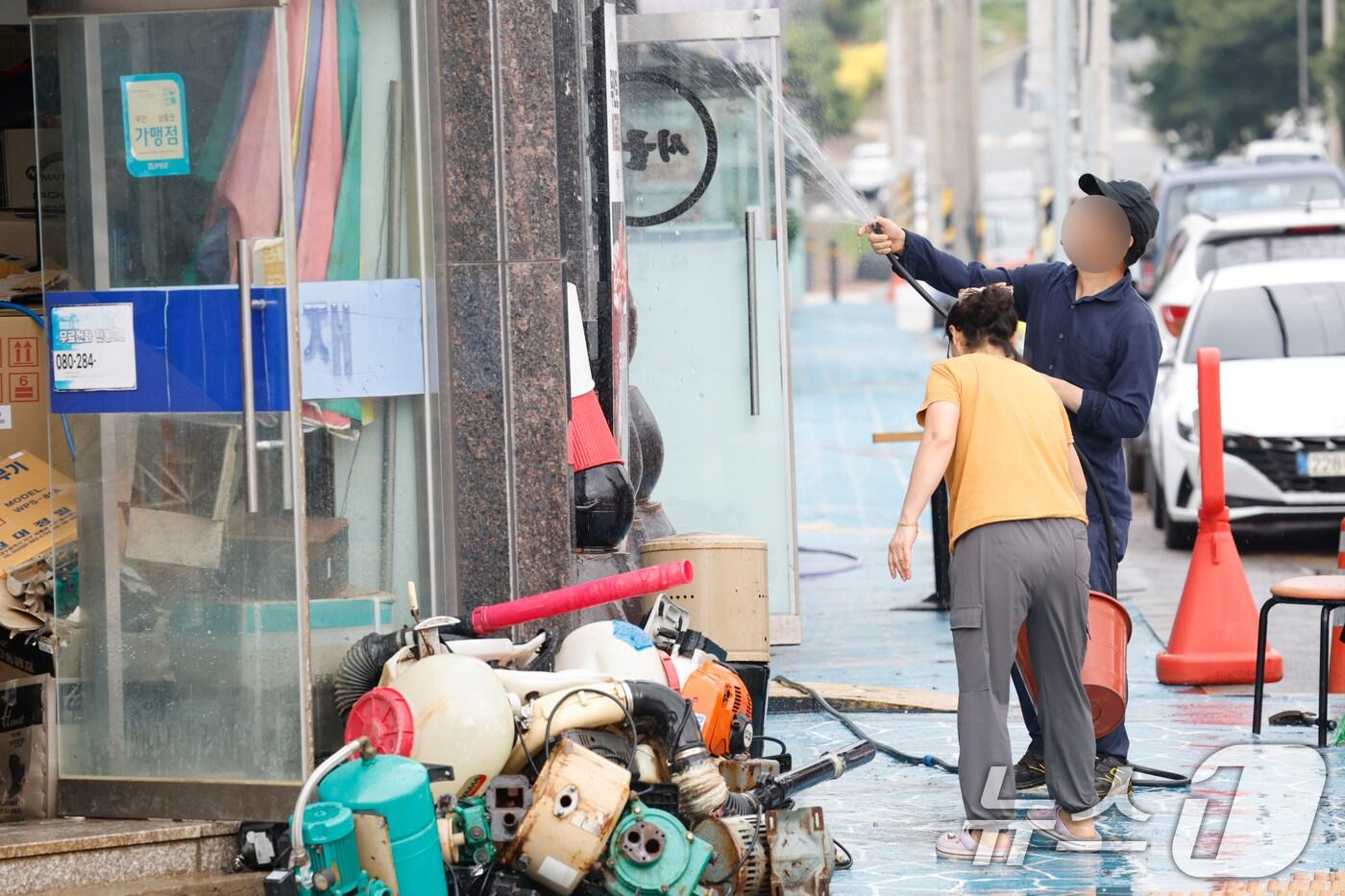 4일 전남 무안군 무안보건소 앞 한 가게에서 전날 내린 폭우로 가게가 침수돼 상인들이 물로 가게를 씻어내고 있다. 2025.8.4/뉴스1 ⓒ News1 김태성 기자