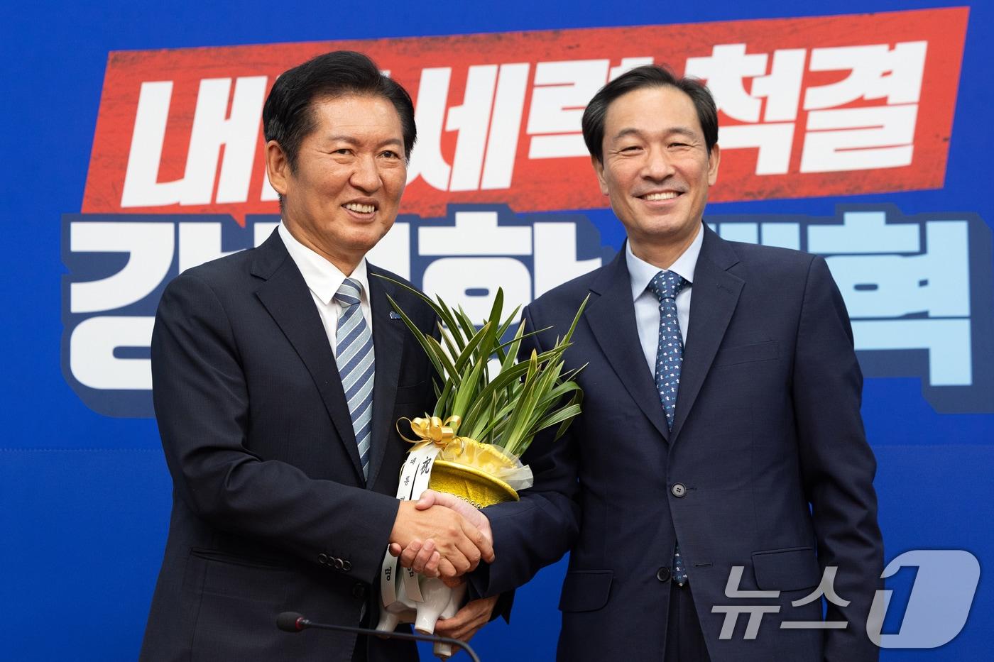 정청래 더불어민주당 대표가 지난달 4일 오후 서울 여의도 국회에서 우상호 대통령실 정무수석으로부터 대통령 축하 난을 받고 있다. 2025.8.4/뉴스1 ⓒ News1 이승배 기자