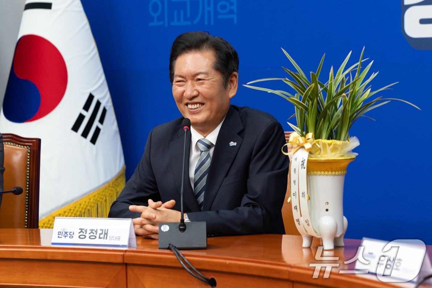 정청래 더불어민주당 신임 대표가 4일 오후 서울 여의도 국회에서 우상호 대통령실 정무수석으로부터 대통령 축하 난을 받고 미소 짓고 있다. 2025.8.4/뉴스1 ⓒ News1 이승배 기자