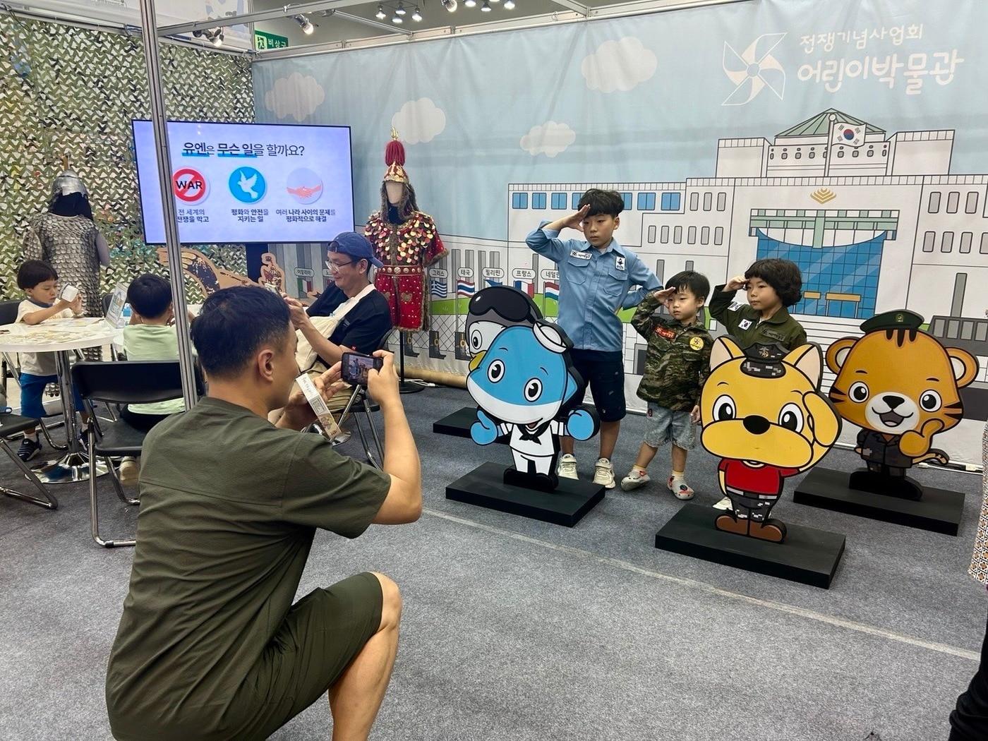 본문 이미지 - 2025 부산 어린이박람회 &#39;전쟁기념관 어린이박물관 체험부스&#39;를 방문한 어린이들이 &#39;군복 입기체험&#39;을 하는 모습.&#40;전쟁기념사업회 제공&#41;