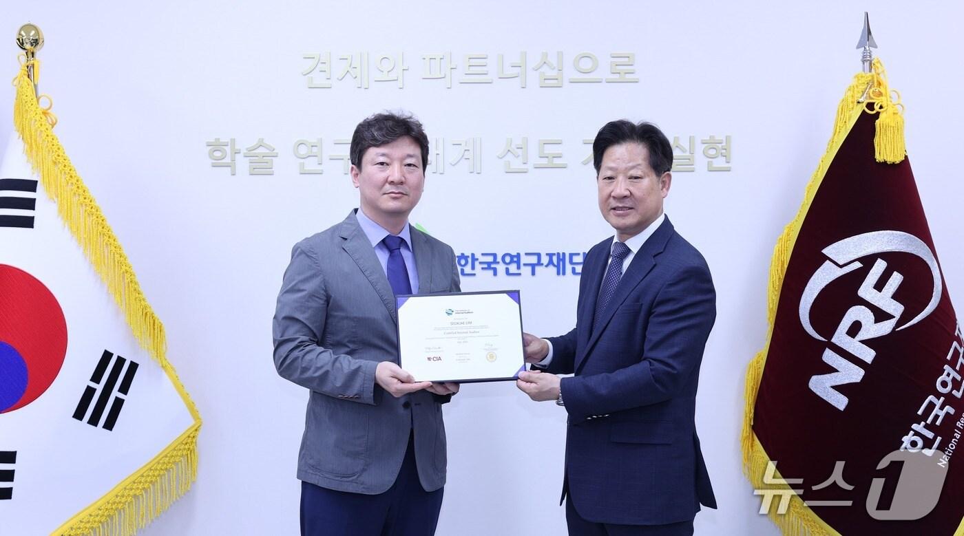 한국연구재단 임석재 선임연구원(온쪽)과 강성식 상임감사가 CIA 자격증 취득 기념사전을 촬영하고 있다.(한국연구재단 제공) /뉴스1