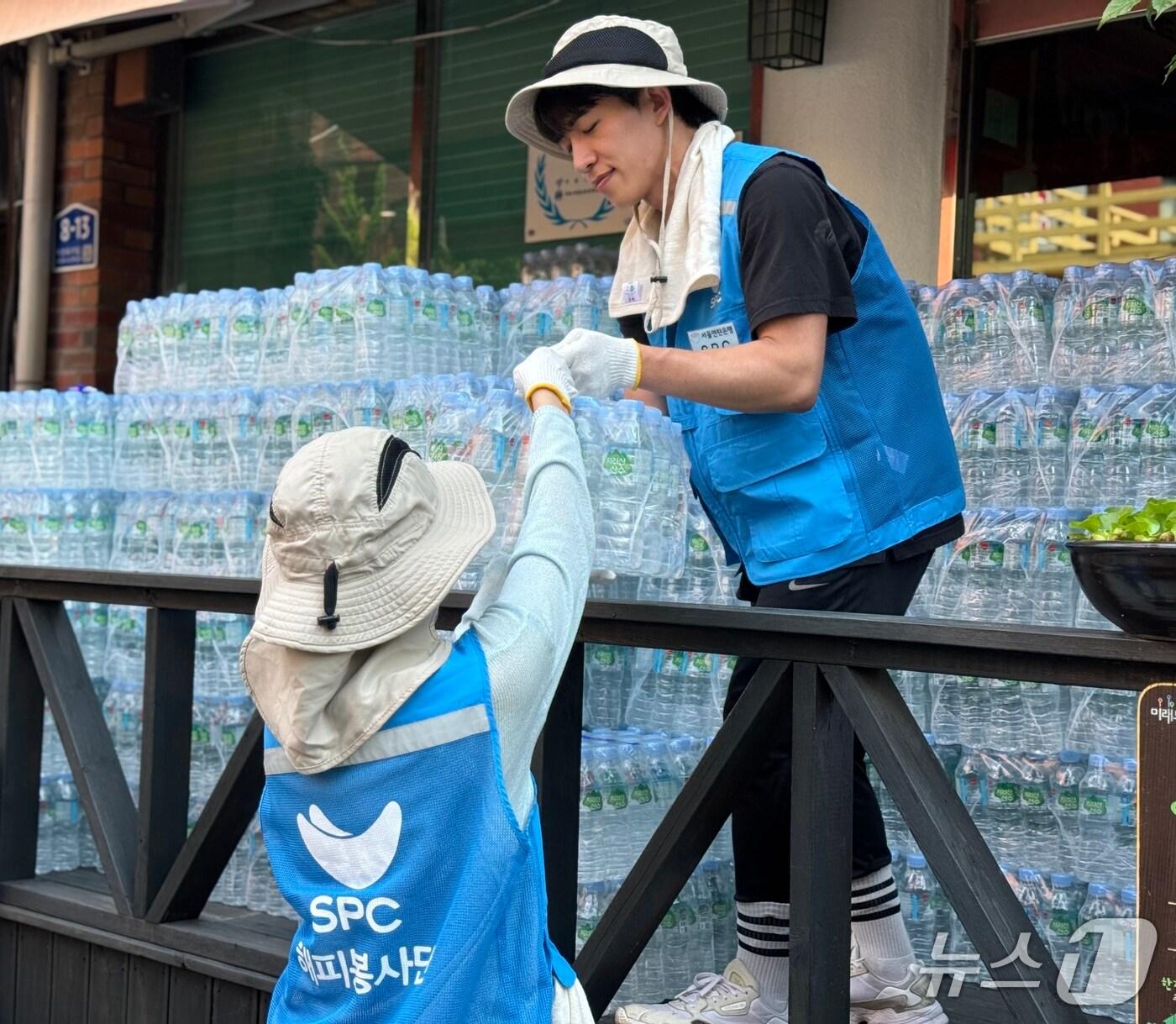 본문 이미지 - 서울 용산구 한강로동 주거단지에서 5일 SPC그룹 임직원들이 폭염으로 어려움을 겪고 있는 취약계층에게 전달할 생수를 나르고 있다. (사진제공 SPC그룹)