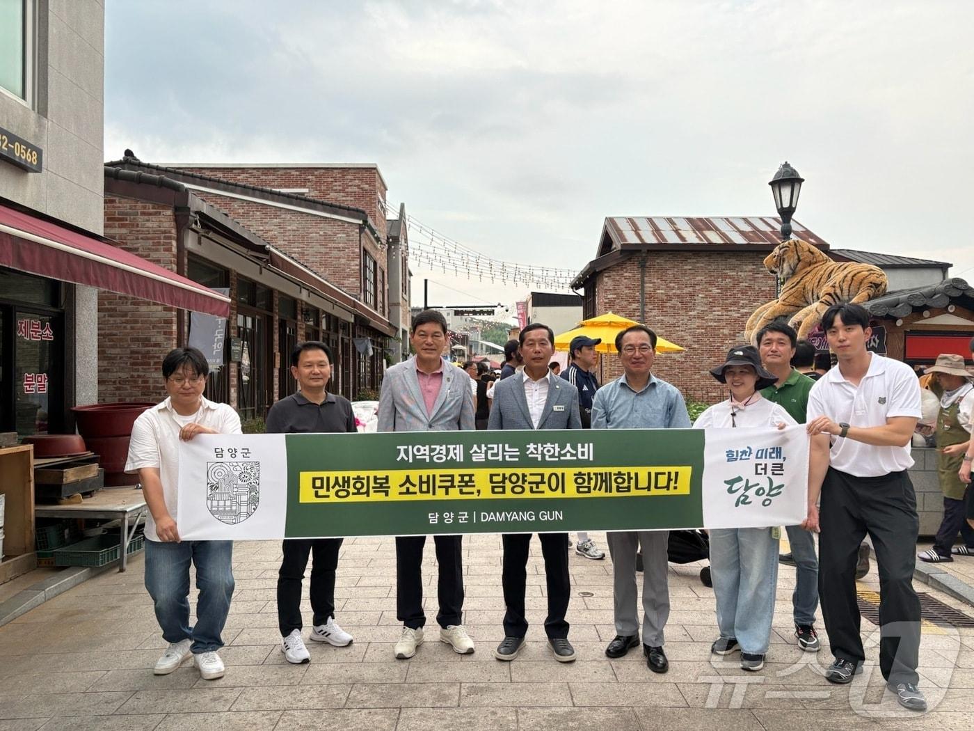 본문 이미지 - 정철원 전남 담양군수가 다미담예술구 상인들과 함께 민생회복소비쿠폰 캠페인을 전개하며 사용을 독려하고 있다.&#40;담양군 제공. 재배포 및 DB 금지&#41;