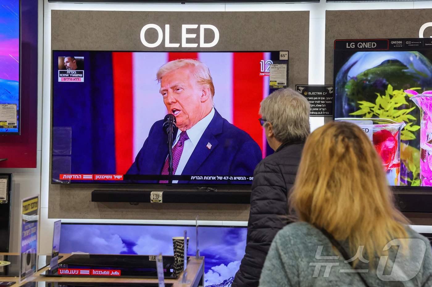 이스라엘에서 길가던 시민들이 도널드 트럼프 미국 대통령의 47대 미 대통령 취임 연설을 보고 있다. 2025.01.20.ⓒ AFP=뉴스1