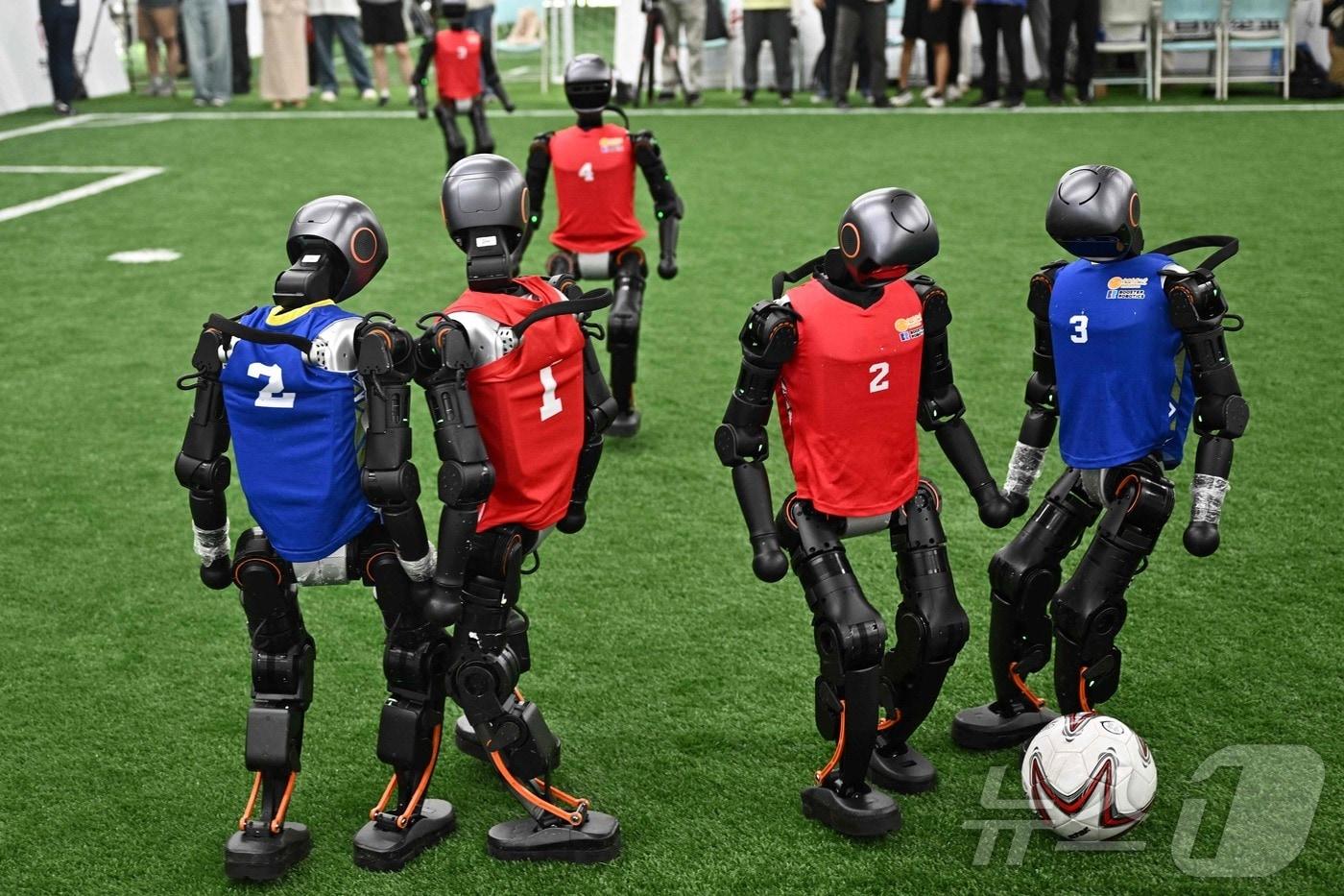 14일 베이징에서 개막하는 세계 휴머노이드 로봇 올림픽을 앞두고 열린 리허설에서 휴머노이드 로봇들이 공을 두고 경쟁하고 있다. 2025.8.4 ⓒ AFP=뉴스1 ⓒ News1 정은지 특파원