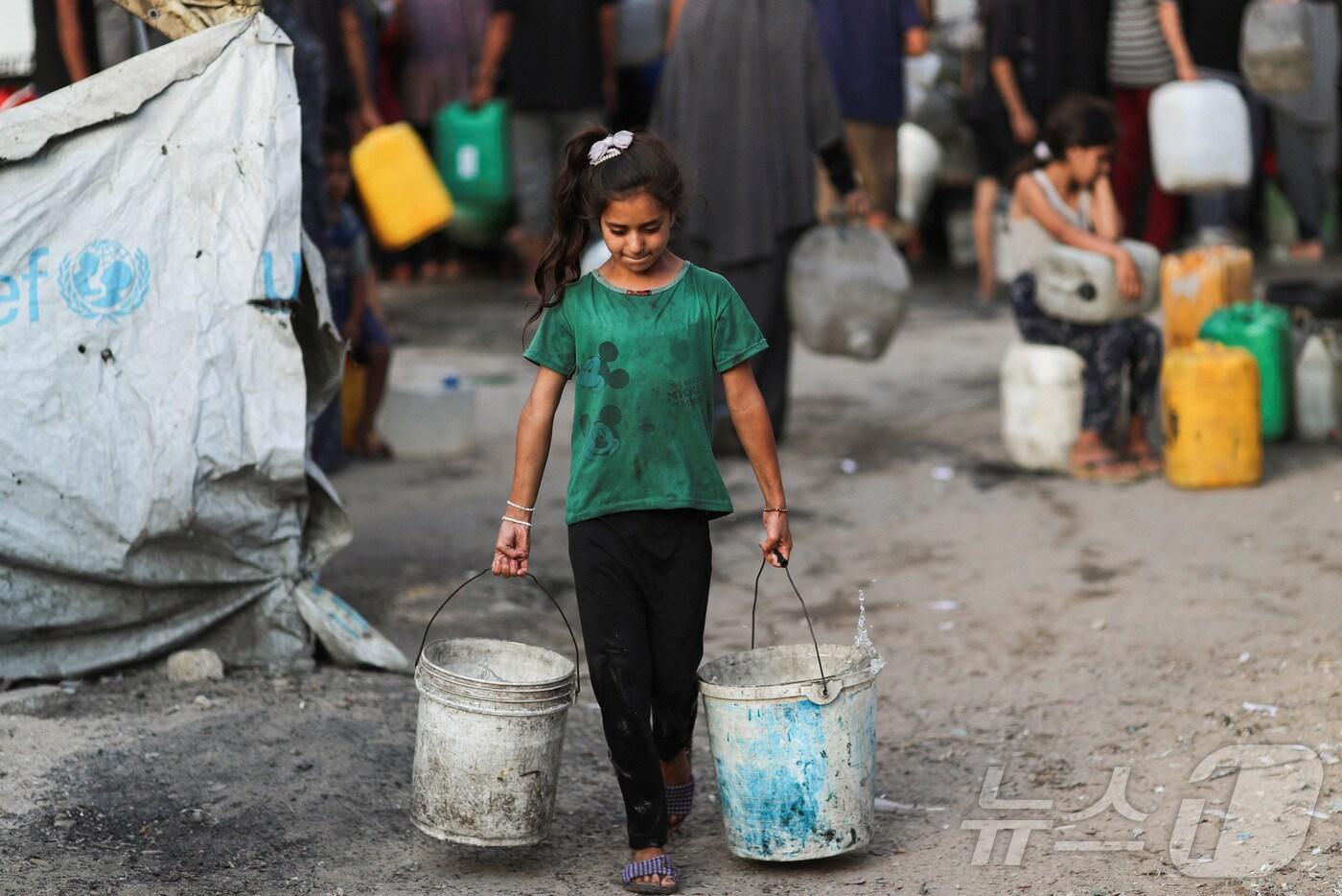 극심한 물 부족을 겪고 있는 가자시티에서 6일(현지시간) 한 소녀가 양동이를 들고 걷고 있다. 2025.08.06. ⓒ 로이터=뉴스1 ⓒ News1 권영미 기자
