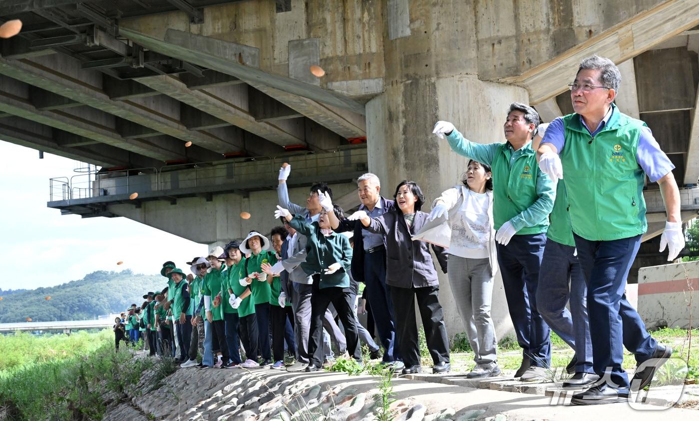 김진열 군위군수와 군위군 새마을지도자들이 위천 강물에 EM 흙공을 던지고 있다. (군위군 제공. 재판매 및 DB금지)