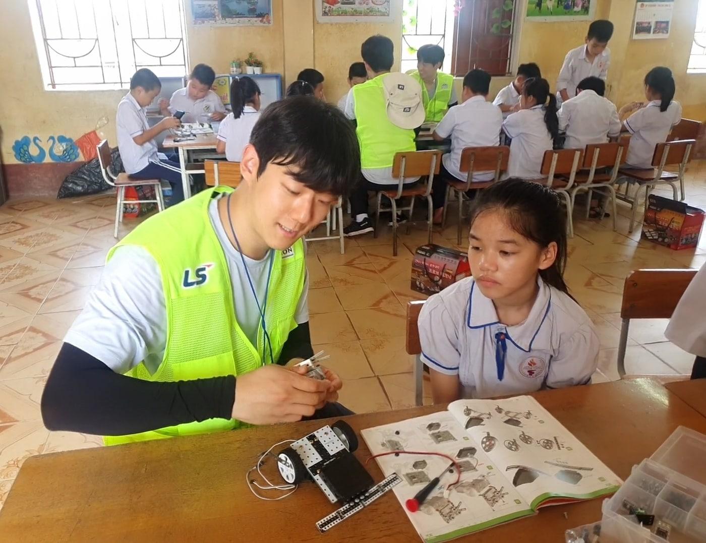 본문 이미지 - LS 대학생 해외봉사단 28기 단원들이 베트남 팜타이 초등학교에서 학생들을 대상으로 과학키트 만들기 체험학습을 진행하고 있다(LS 제공). ⓒ 뉴스1