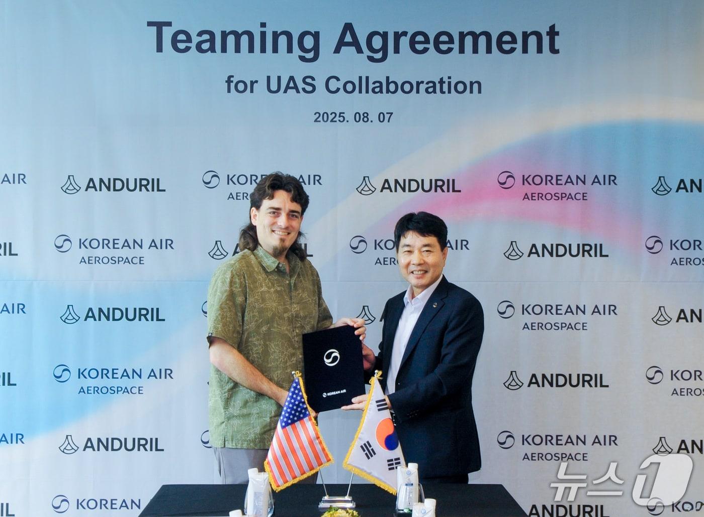 본문 이미지 -  대한항공은 7일 미국 방산기업 안두릴(Anduril)과 한국 및 아시아·태평양 지역 무인 항공기 분야의 파트너십 구축을 위한 협력합의서(TA)에 서명했다. 사진은 협약식에 참석한 임진규 대한항공 항공우주사업본부장(오른쪽)과 팔머 럭키 안두릴 창업자(왼쪽)가 기념촬영을 하는 모습.(대한항공 제공)