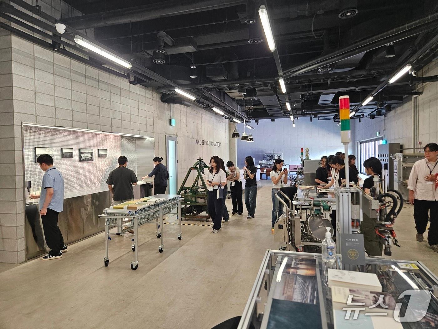 본문 이미지 - 아모레퍼시픽 오산 공장을 탐방 중인 대학생들 모습.ⓒ 뉴스1/김진희 기자.