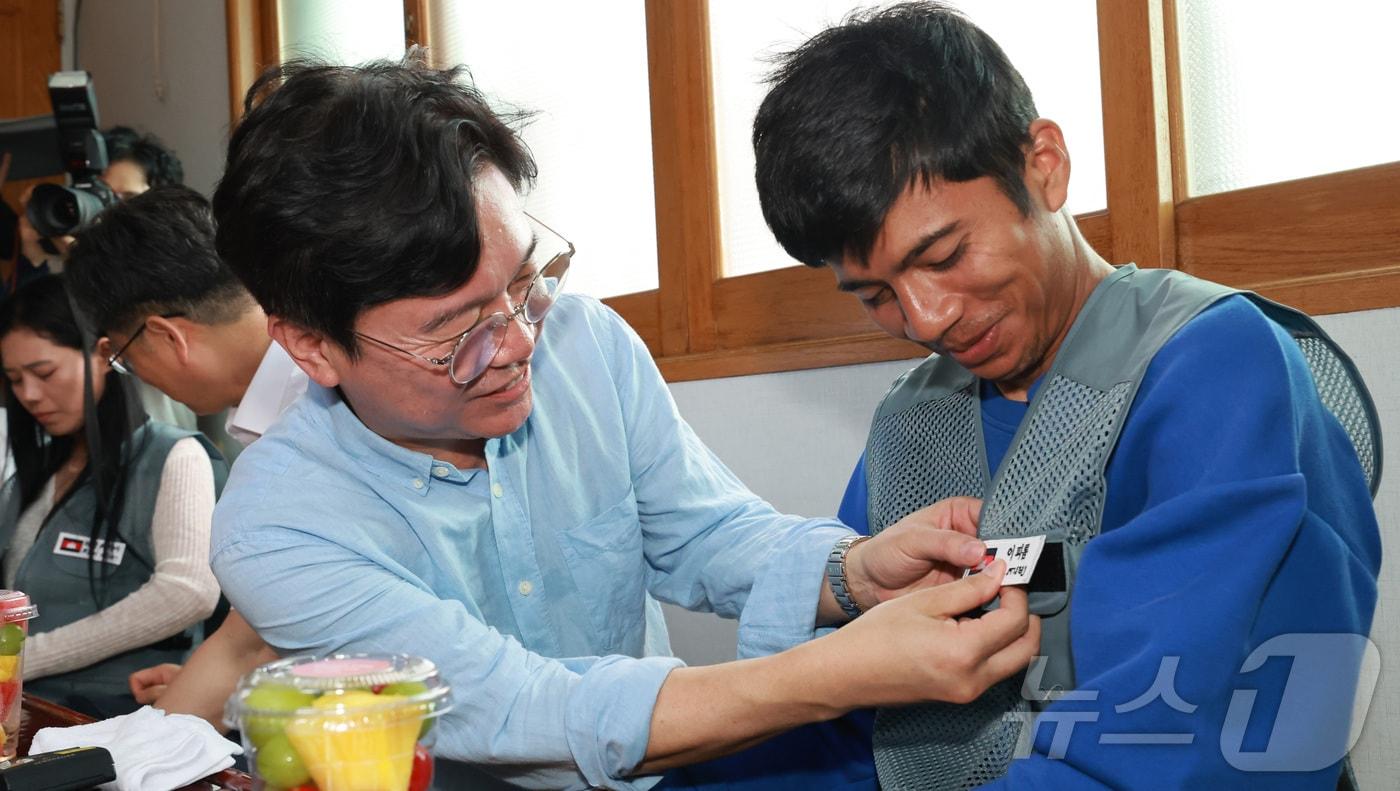 김영훈 고용노동부 장관이 8일 안호영 환경노동위원회 위원장과 함께 전북 완주군 외국인 고용 농가를 방문하여 무더위 속 외국인 노동자들의 목소리를 청취하고, 미리 준비한 외국인 노동자들의 이름이 모국어와 한국어로 새겨진 명찰을 부착해 주고 있다.&#40;고용노동부 제공. 재판매 및 DB 금지&#41; 2025.8.8/뉴스1