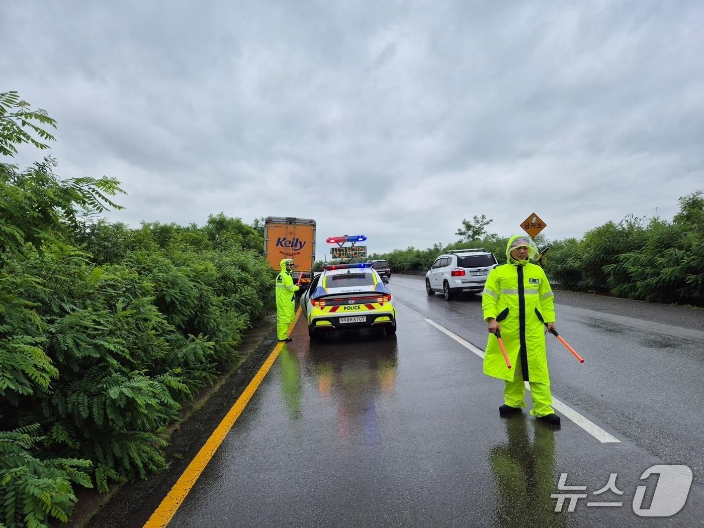 본문 이미지 - 전북경찰청 소속 경찰관들이 빗길 교통사고 현장을 통제하는 모습. (전북경찰청 제공. 재판매 및 DB금지)