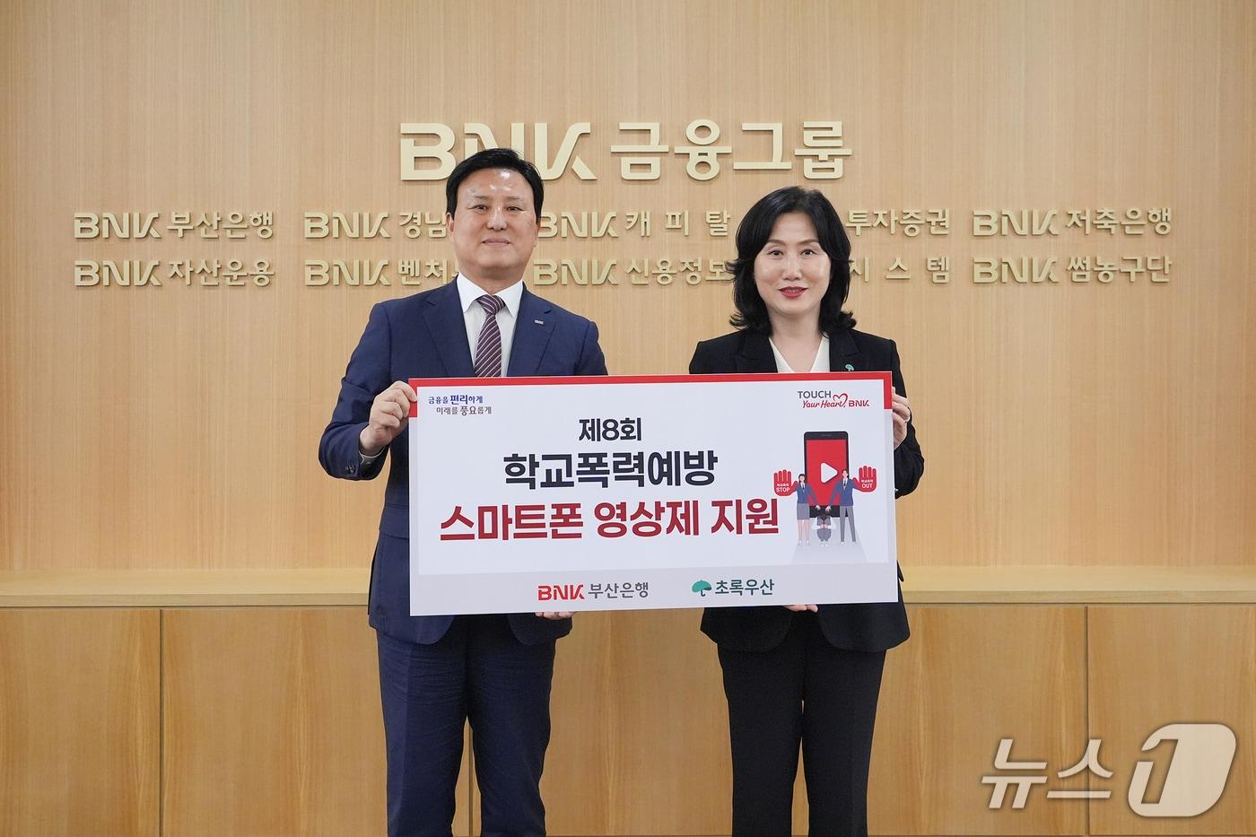 1일 오후 부산은행 본점에서 열린 '제8회 학교폭력예방 스마트폰 영상제 후원금 전달식'에서 김용규 BNK부산은행 경영전략그룹장과 이수경 초록우산 어린이재단 부울경권역총괄본부장이 기념촬영을 하고 있다. (부산은행 제공. 재판매 및 DB 금지)