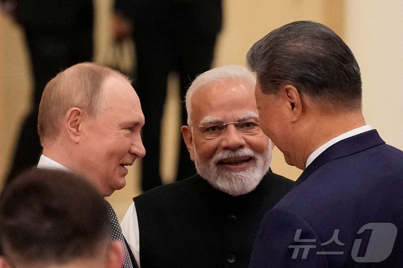블라디미르 푸틴 러시아 대통령&#40;왼쪽부터&#41;과 나렌드라 모디 인도 총리, 시진핑 중국 국가주석이 1일 중국 톈진에서 열린 상하이협력기구&#40;SCO&#41; 정상회의에서 대화하고 있다. 2025.09.01 ⓒ 로이터=뉴스1 ⓒ News1 이지예 객원기자