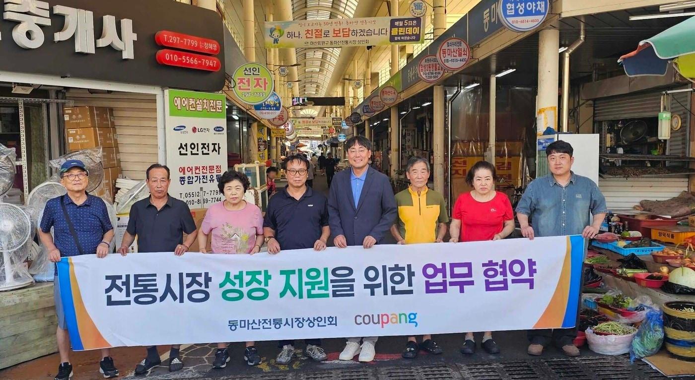 윤상수 동마산전통시장상인회장(왼쪽에서 네번째), 김종춘 쿠팡 서비스정책실 상무(왼쪽에서 다섯번째), 시장상인들이 업무 혁약 기념 사진을 촬영하고 있다. (쿠팡 제공).