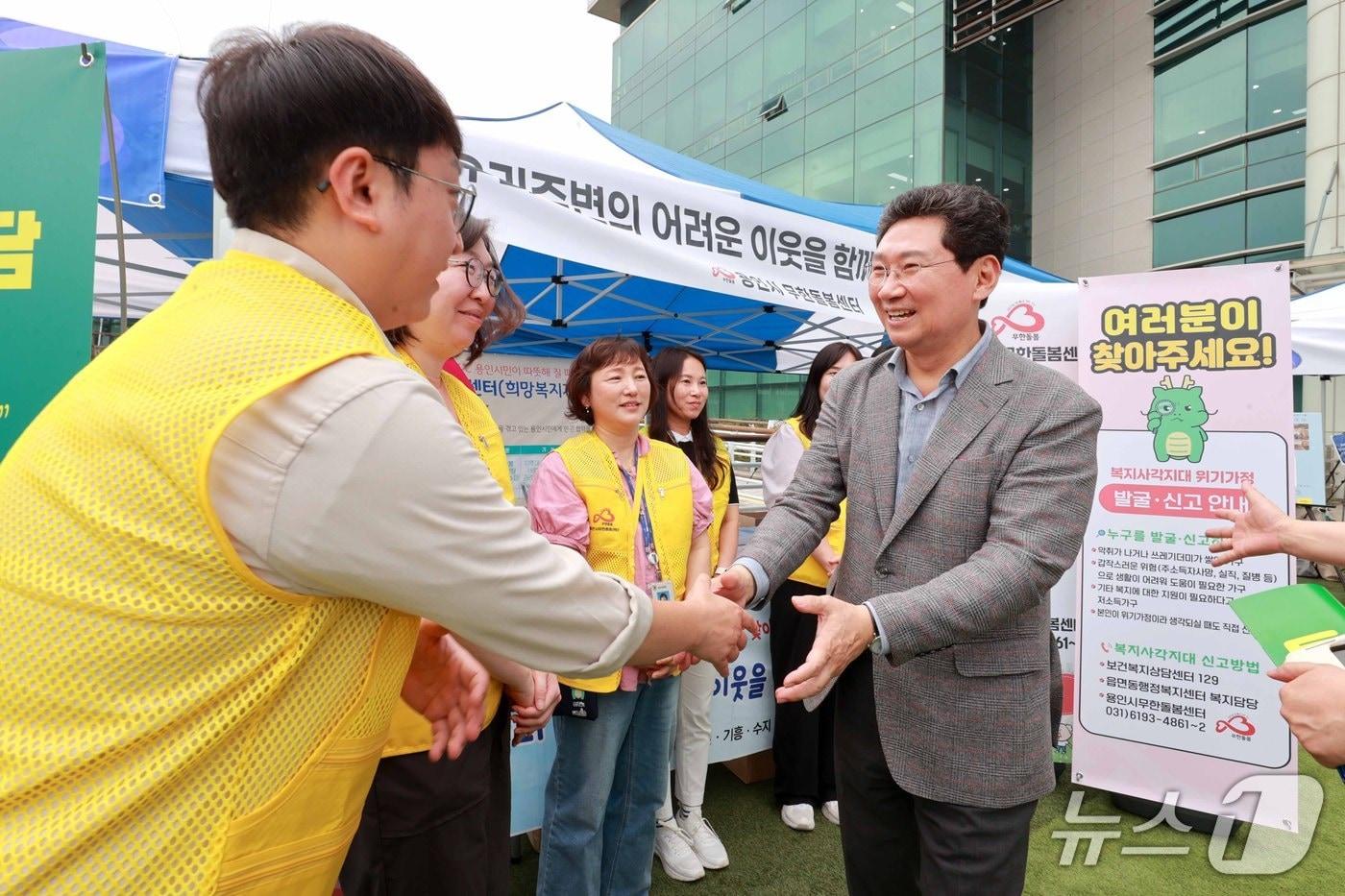 이상일 시장&#40;오른쪽&#41;이 9일 시청 하늘광장에 마련된 사회복지박람회 부스를 돌며 복지시설 종사자들을 격려하고 있는 모습.&#40;용인시 제공&#41;