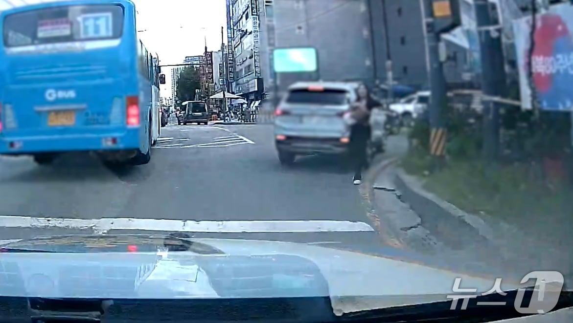 본문 이미지 - A 씨가 B 군(3)을 품에 안은 채 차량에서 내려 경찰에 도움을 요청하는 모습. (경기남부경찰청 제공. 재판매 및 DB 금지) 2025.9.10/뉴스1