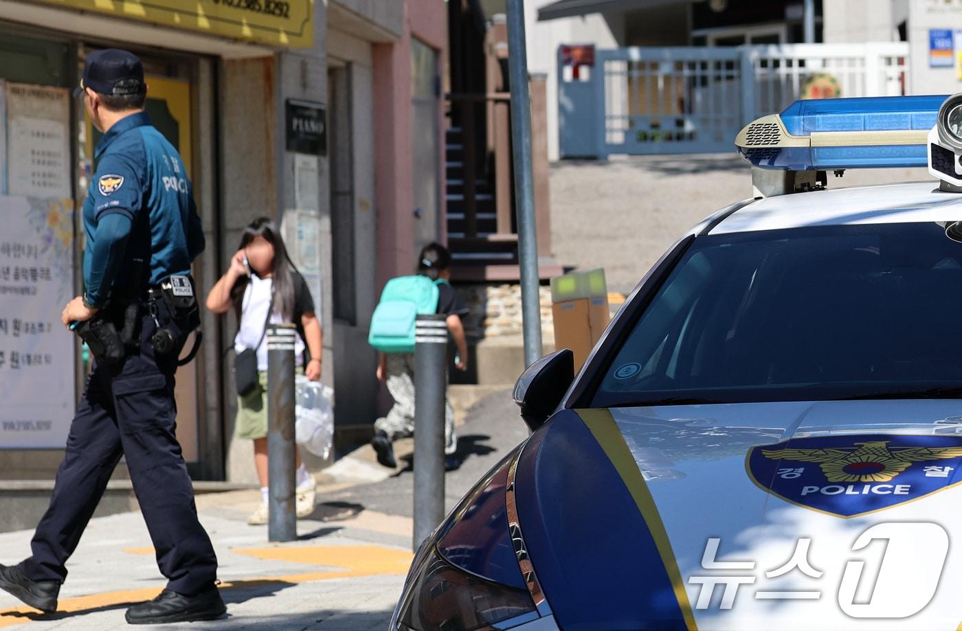 초등학교 인근 유괴 미수와 불법 촬영 사건 등으로 학부모들의 불안감이 확산하는 가운데 지난 10일 오후 서울 서대문구의 한 초등학교 정문 앞에서 경찰관이 학생들의 하교를 지켜보고 있다. 2025.9.10/뉴스1 ⓒ News1 오대일 기자