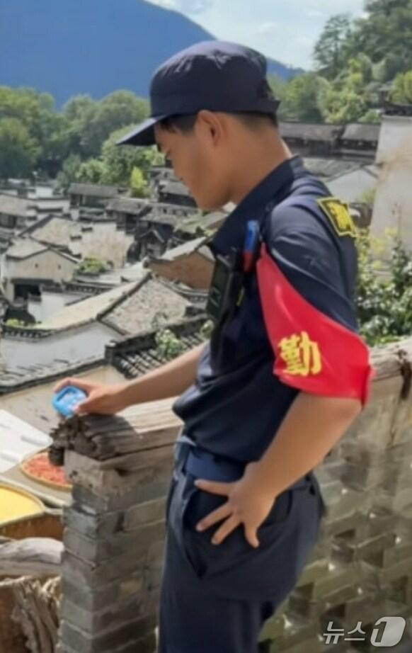 본문 이미지 - 장시성 우위안현 황린 관광지에서 직원이 타이머를 들고 있다. (웨이보 갈무리)