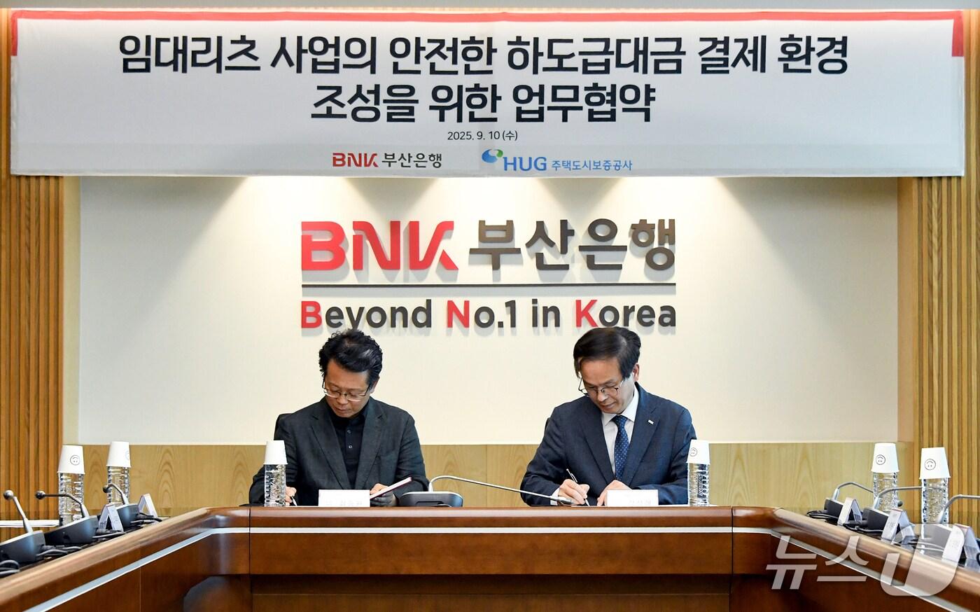 BNK부산은행 문현동 본점에서 열린 임대리츠 사업의 안전한 하도급대금 결제 환경 조성을 위한 업무협약식에서 강석래 BNK부산은행 기업고객그룹장(오른쪽)과 최종원 주택도시보증공사 기금사업본부장이 협약서에 서명하고 있다. (BNK부산은행 제공. 재판매 및 DB 금지)