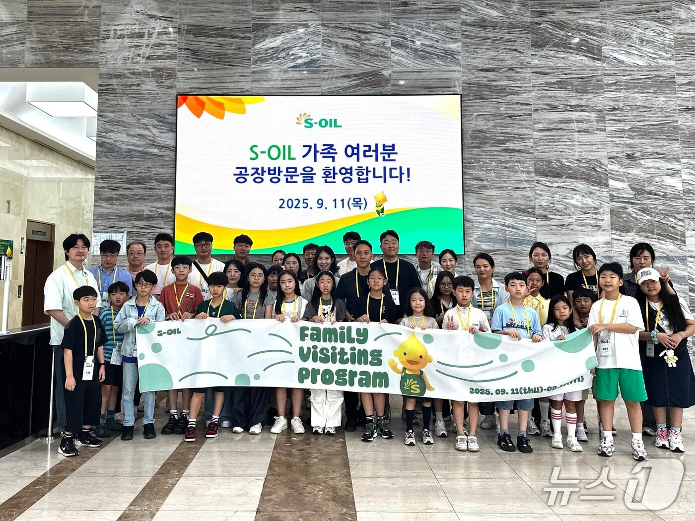 본문 이미지 - 에쓰오일 가족 초청 행사에 참여한 임직원 가족들이 울산 공장 본관에서 기념촬영을 하고 있다. (사진제공 = 에쓰오일) 