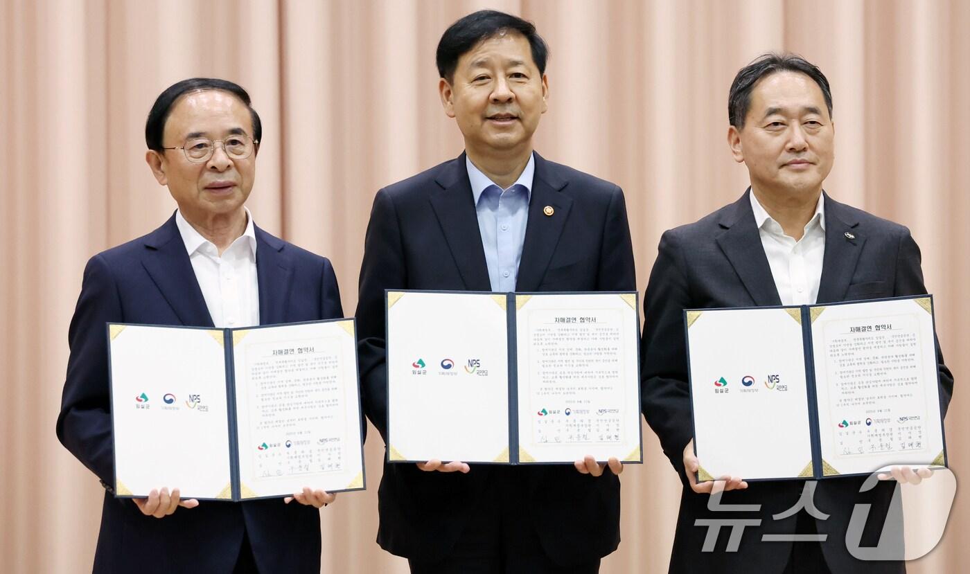 11일 전북 임실군 임실치즈테마파크 일원에서 열린 임실군-기획재정부 국민연금공단 자매결연 협약식에서 관계자들이 기념촬영을 하고 있다. 왼쪽부터 심민 임실군수, 구윤철 부총리 겸 기획재정부 장관, 김태현 국민연금공단 이사장. ⓒ News1 유경석 기자