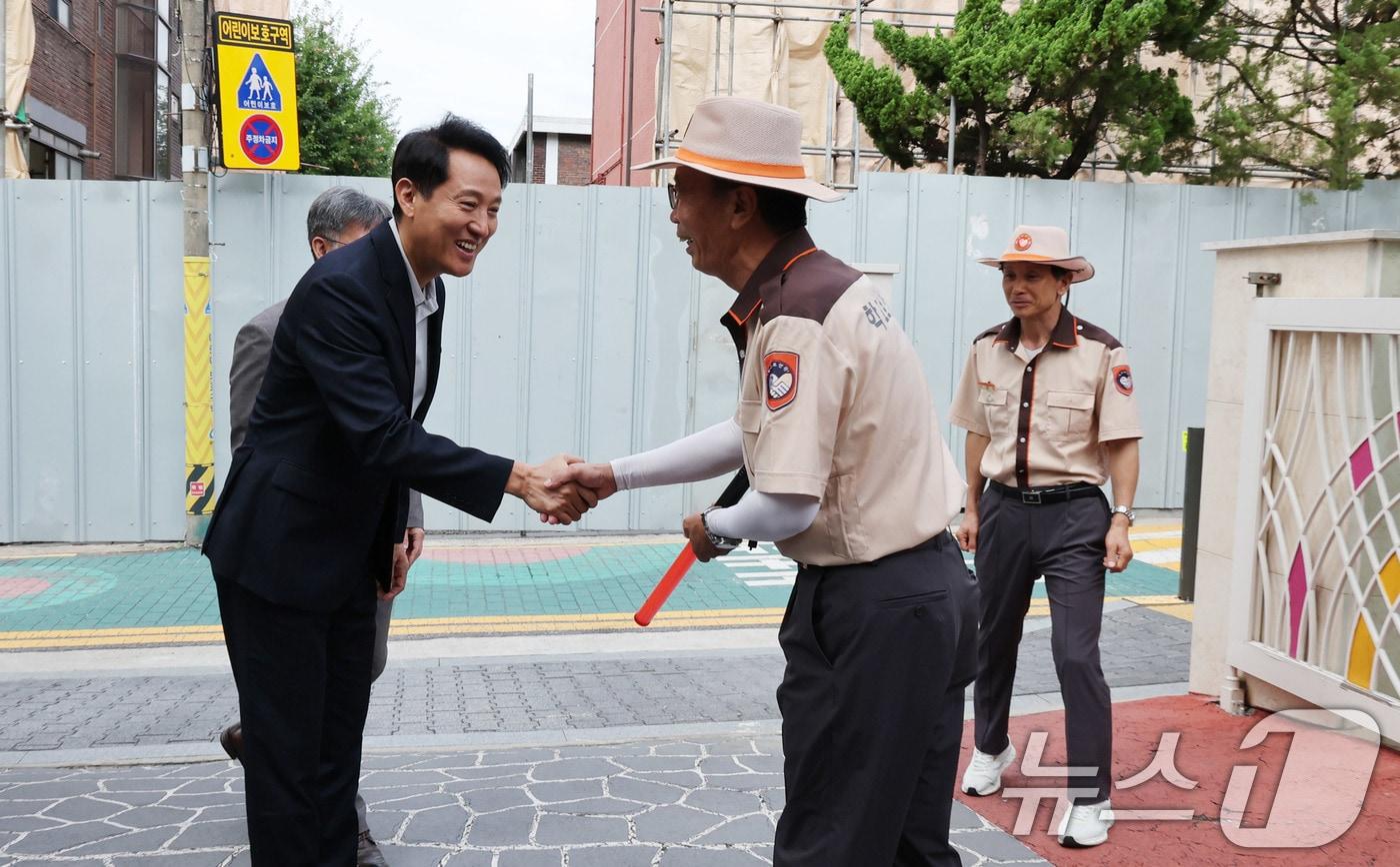 본문 이미지 - 초등학생 등하굣길 안전 관련 현장방문에 나선 오세훈 서울시장이서울 광진구 양남초등학교 찾아 학교 보안관과 인사를 나누고 있다. 2025.9.12 ⓒ 뉴스1 박지혜 기자